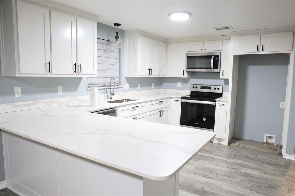 494 Lannius Road Dodd City, TX 75438 - Photo 9 of 40 a kitchen with stainless steel appliances a stove top oven a sink a refrigerator and white cabinets