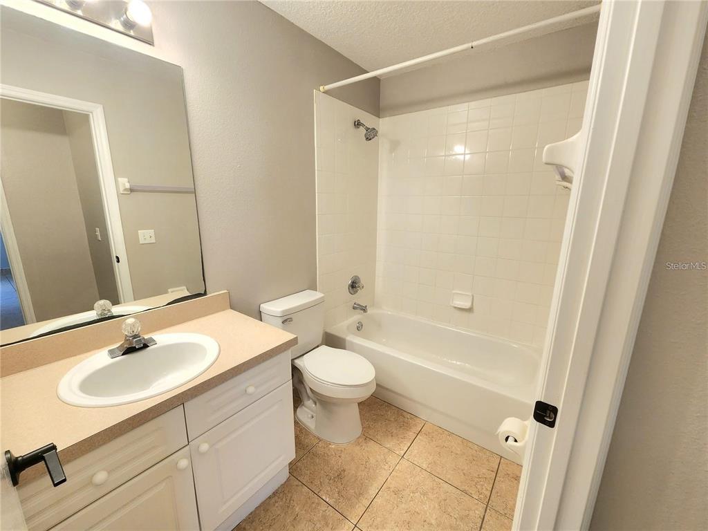 221 Caribbean Drive Davenport, FL 33897 - Photo 9 of 15 a bathroom with a sink a toilet a mirror a vanity and shower