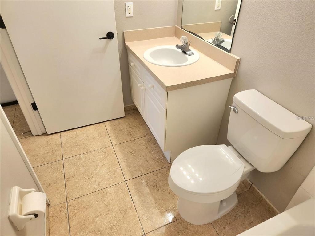 221 Caribbean Drive Davenport, FL 33897 - Photo 10 of 15 a white toilet sitting next to a bathroom sink