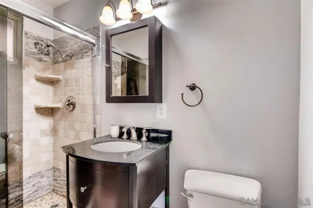 a bathroom with a sink a toilet and shower