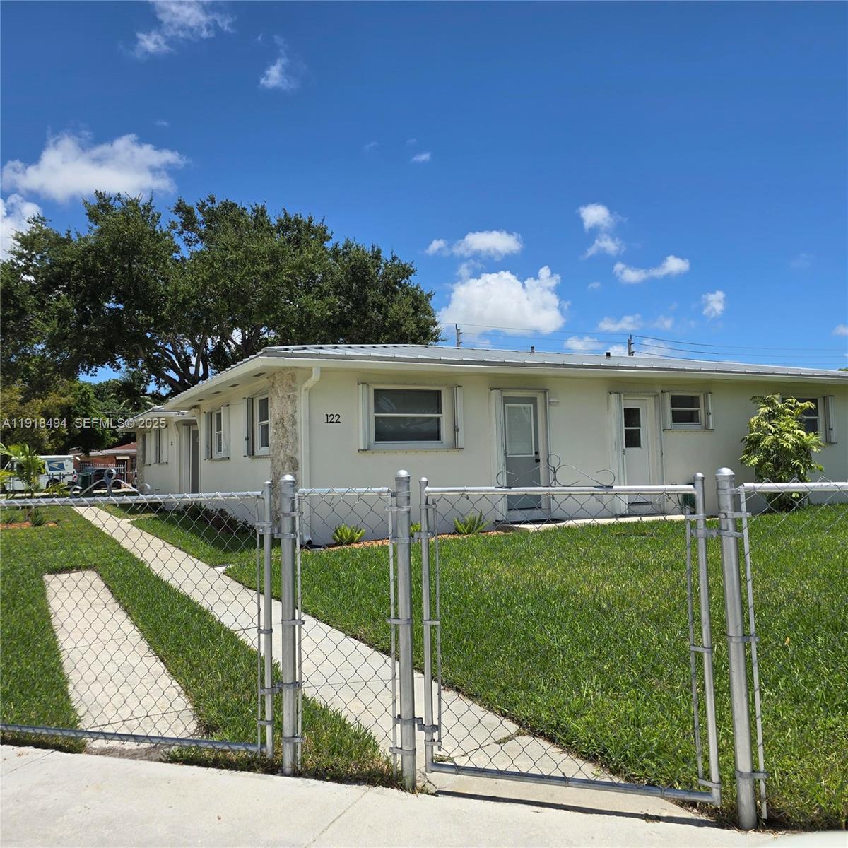 122 Northwest Boulevard, Unit B Miami, FL 33126 - Photo 1 of 17 a front view of a house with a yard