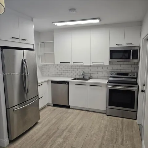 a kitchen with stainless steel appliances a refrigerator sink and microwave