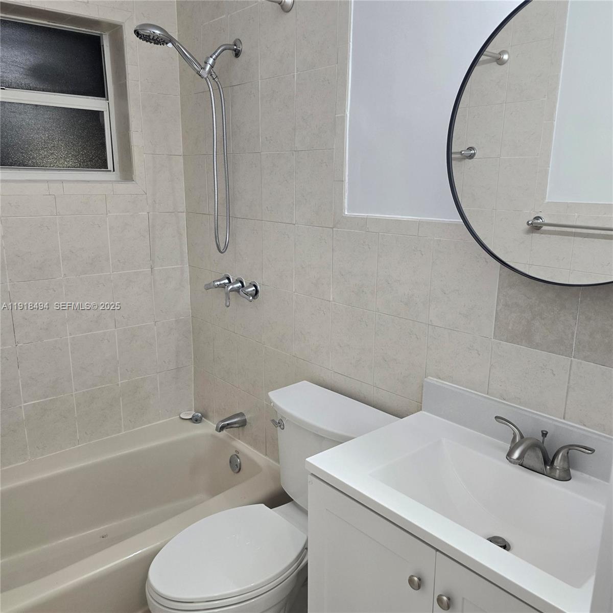 122 Northwest Boulevard, Unit B Miami, FL 33126 - Photo 9 of 17 a bathroom with a sink a toilet and a mirror
