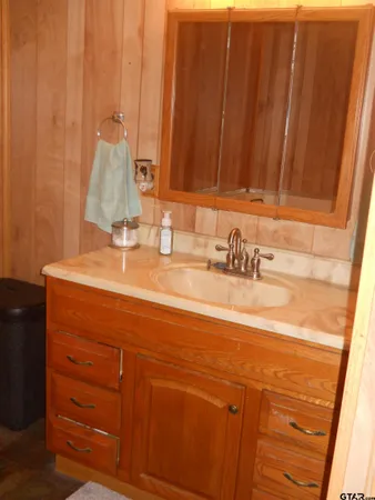 a bathroom with a granite countertop sink toilet and a mirror
