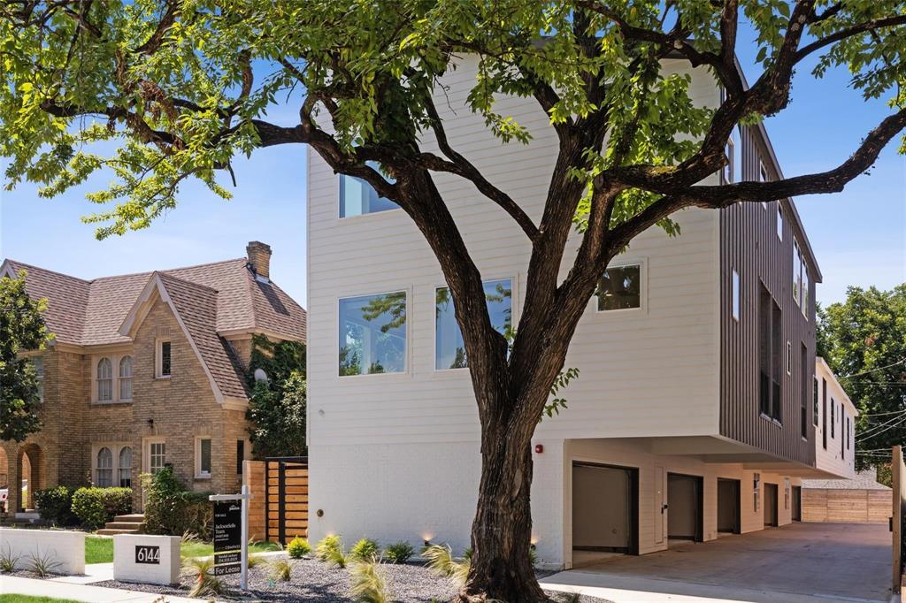 a front view of a house with a tree