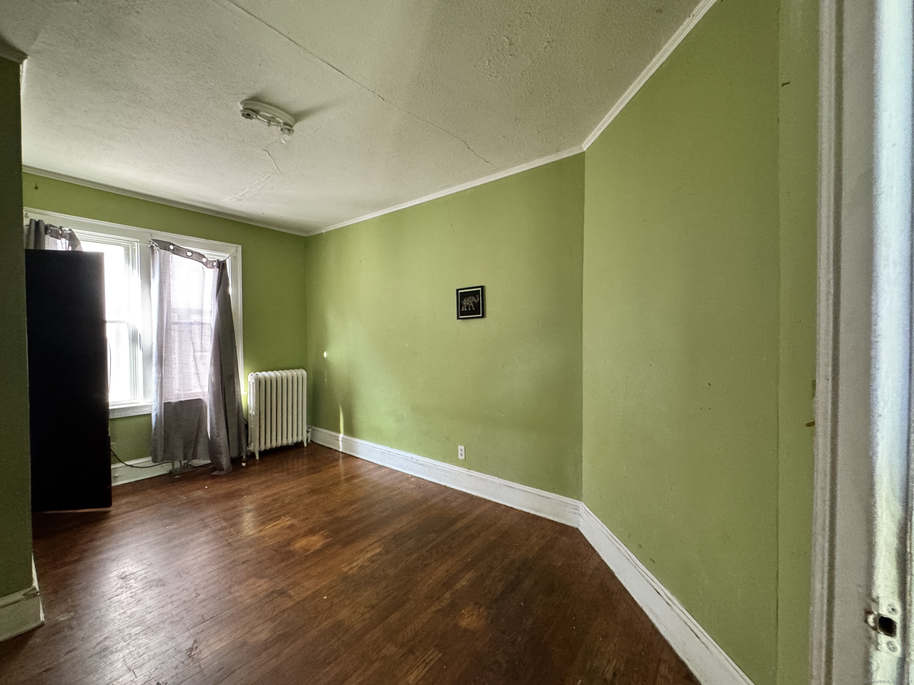102 Rowe Avenue Hartford, CT 06106 - Photo 12 of 28 a view of an empty room with a window and wooden floor
