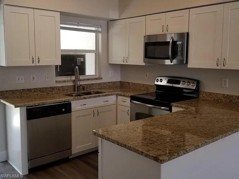 8208 Matanzas Road Fort Myers, FL 33967 - Photo 4 of 9 a kitchen with stainless steel appliances granite countertop a sink stove and microwave