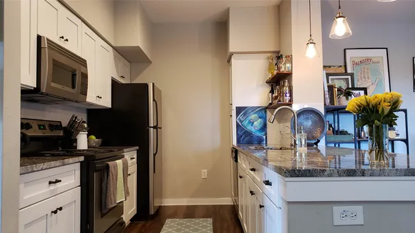 a kitchen with stainless steel appliances granite countertop a refrigerator a stove and a sink
