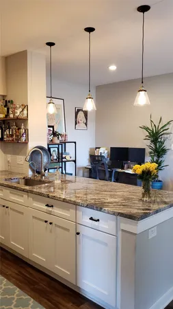 a kitchen with stainless steel appliances granite countertop a sink a stove and a wooden floors