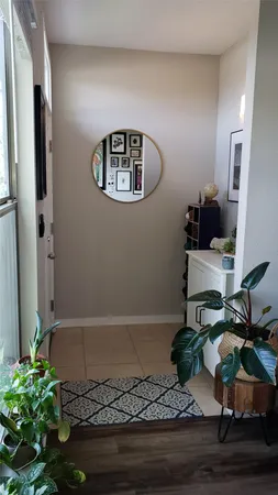 a view of a hallway with wooden floor and a potted plant