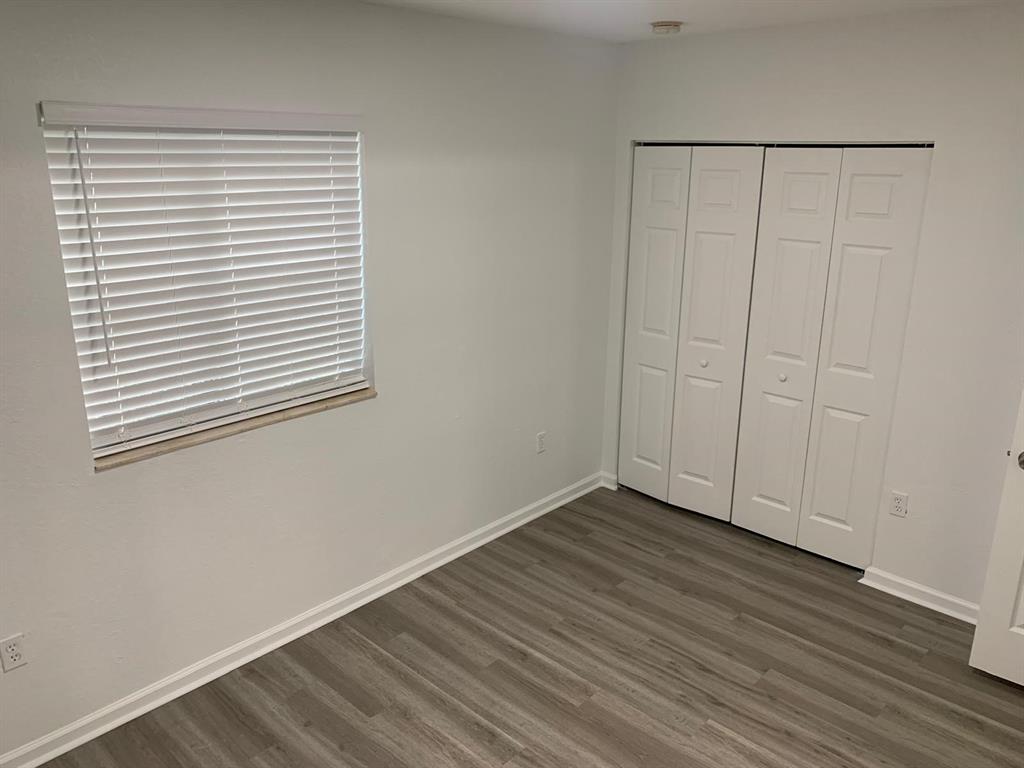 2663 Southwest 82nd Avenue, Unit 104 Miramar, FL 33025 - Photo 13 of 28 a view of an empty room with wooden floor and a window