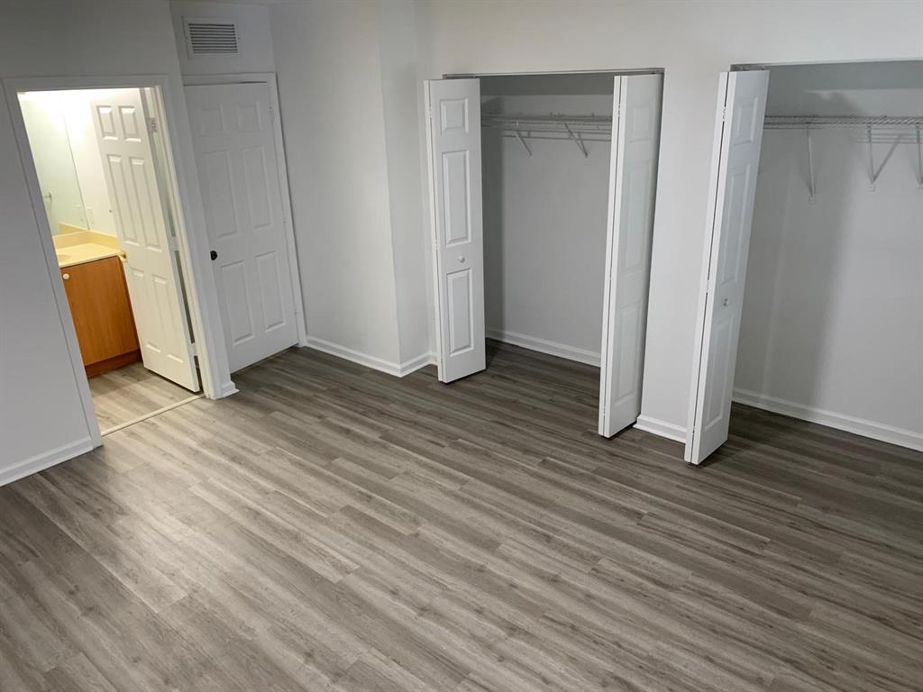 2663 Southwest 82nd Avenue, Unit 104 Miramar, FL 33025 - Photo 22 of 28 an empty room with wooden floor and a bathroom