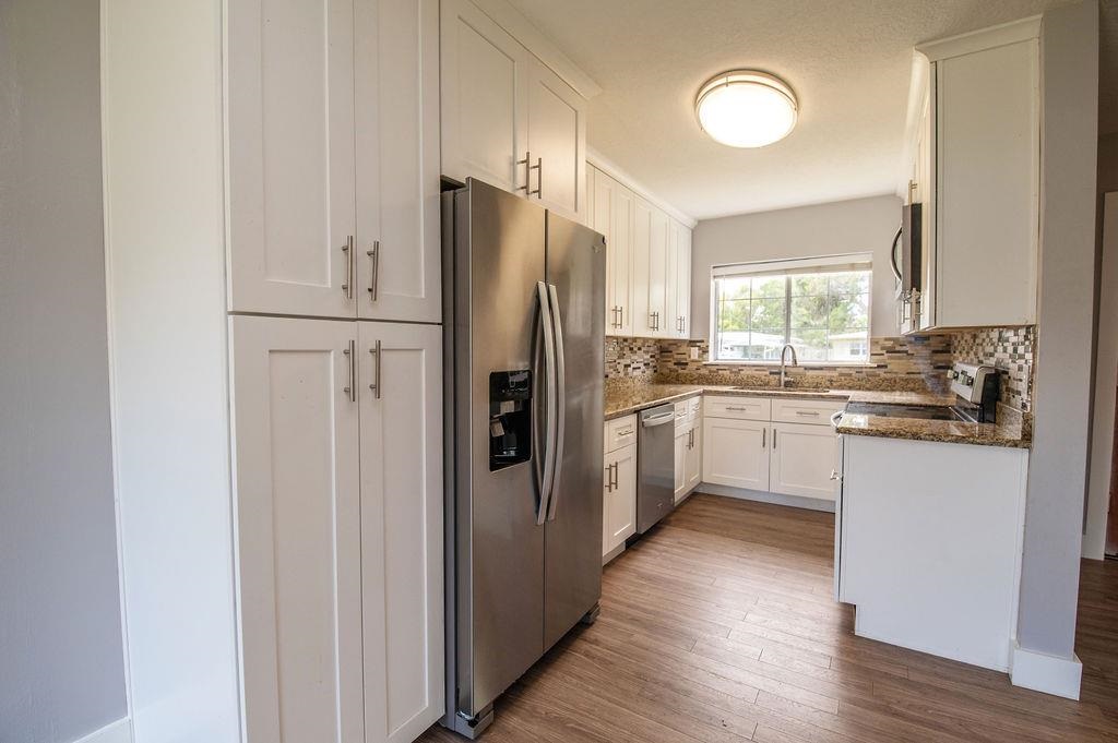 118 Menendez Road St. Augustine, FL 32080 - Photo 4 of 31 a kitchen with white cabinets and stainless steel appliances