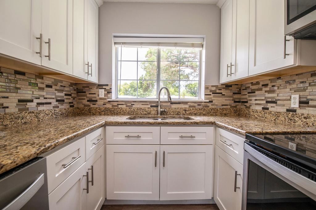 118 Menendez Road St. Augustine, FL 32080 - Photo 5 of 31 a kitchen with granite countertop white cabinets and white stainless steel appliances