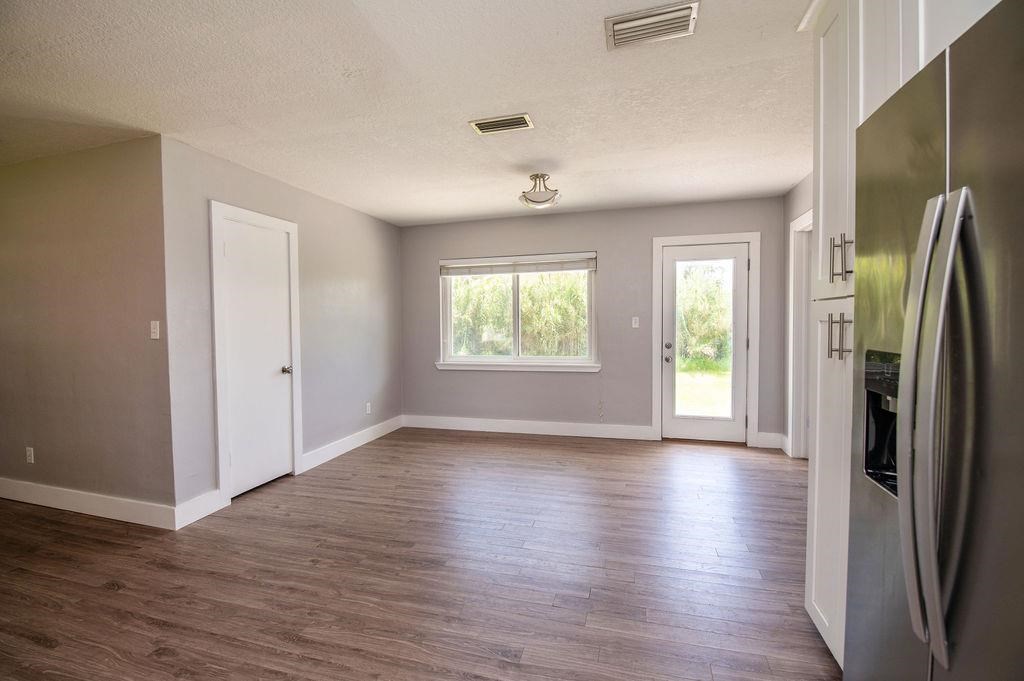 118 Menendez Road St. Augustine, FL 32080 - Photo 7 of 31 an empty room with wooden floor cabinet and windows
