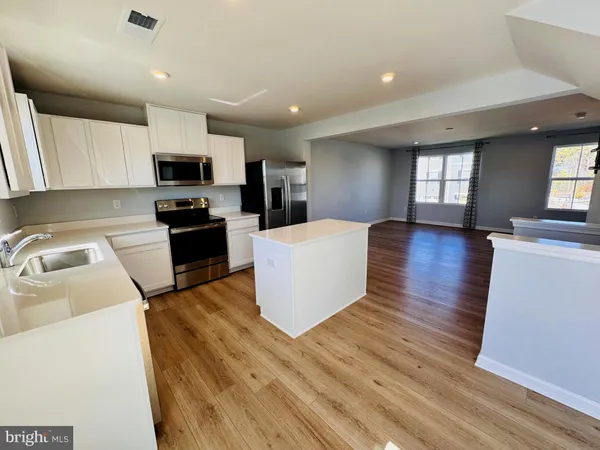 a kitchen with a sink a stove top oven a counter space and cabinets