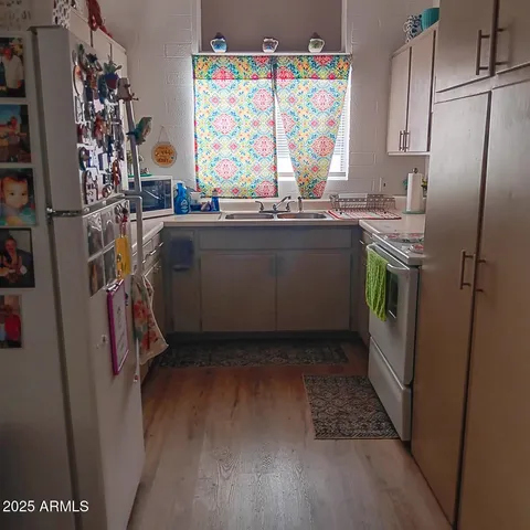 a utility room with stainless steel appliances wooden floor and a window
