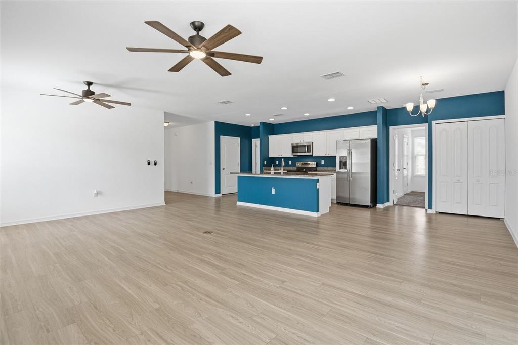 4322 Kiska Road North Port, FL 34288 - Photo 14 of 37 a view of a kitchen with a stove cabinets wooden floor and a ceiling fan