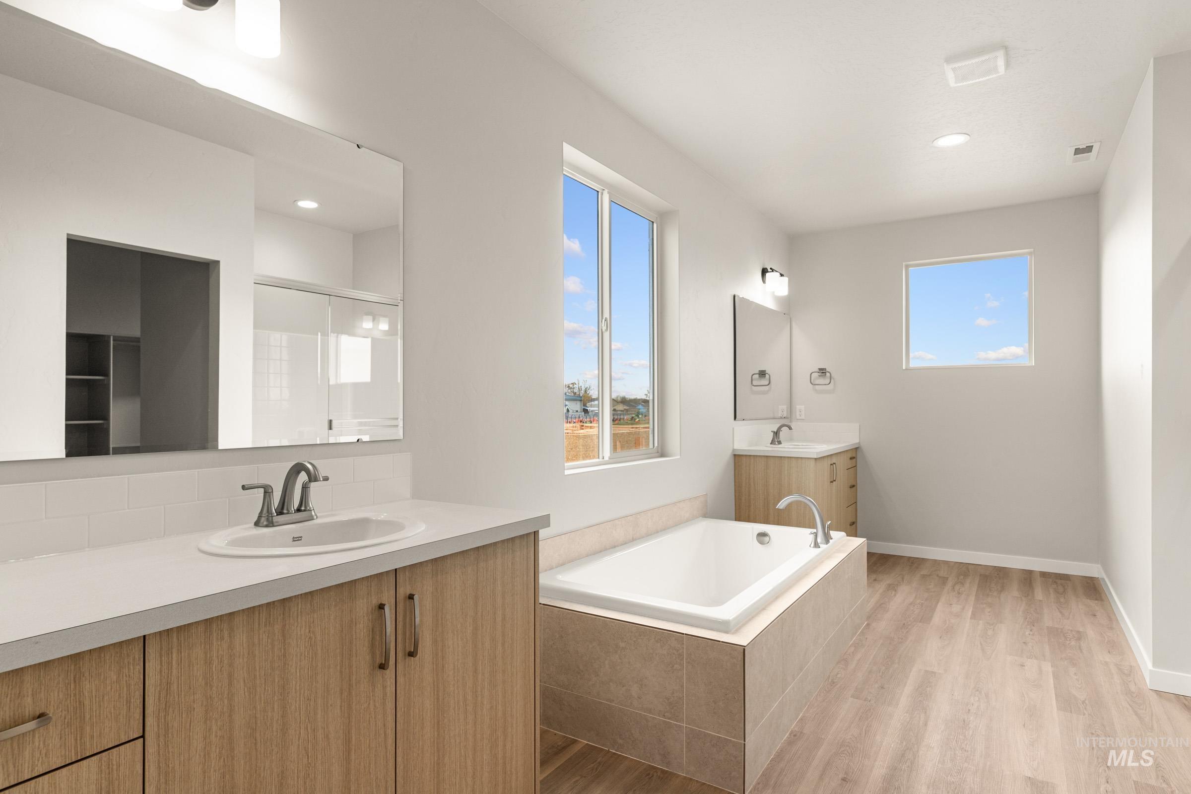 13688 Redway Court Caldwell, ID 83607 - Photo 14 of 26 Bathroom featuring two vanities, light wood-type flooring, a garden tub, recessed lighting, and a shower stall