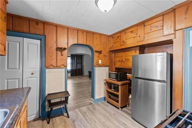 a kitchen with stainless steel appliances granite countertop a refrigerator a stove and a sink with cabinets