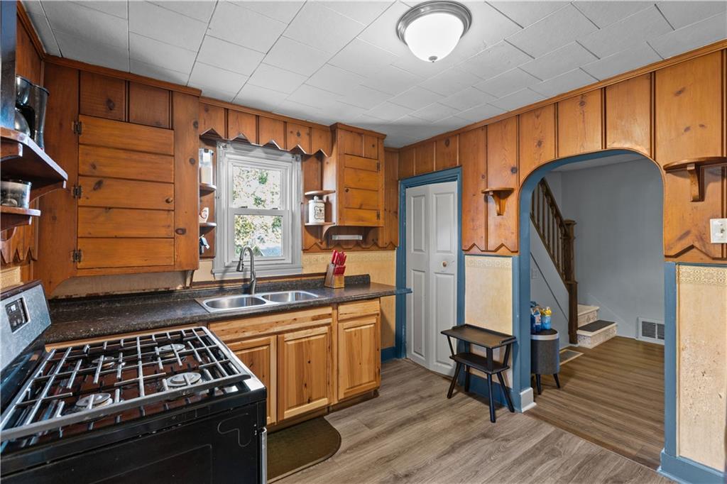 710 5th Street Charleroi, PA 15022 - Photo 16 of 30 a kitchen with stainless steel appliances granite countertop a stove a sink dishwasher and cabinets with wooden floor