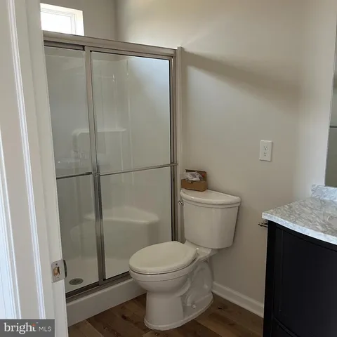 a bathroom with a granite countertop toilet a sink and shower