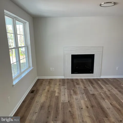a view of an empty room with a fireplace and a window