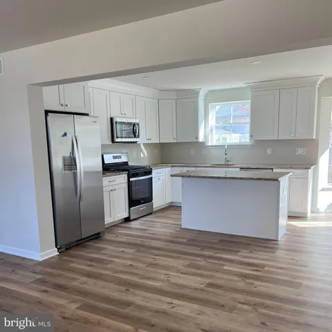 a kitchen with stainless steel appliances granite countertop a refrigerator sink and cabinets