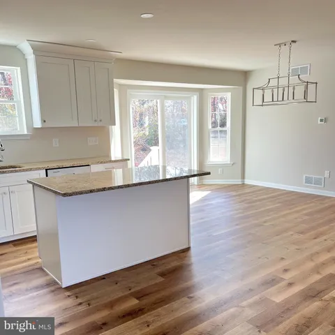 a kitchen with granite countertop wooden floors and wide window