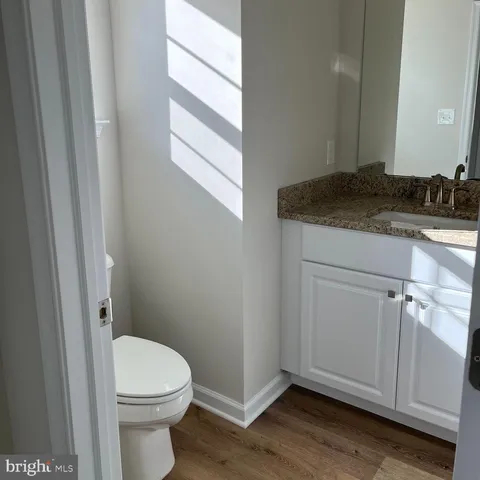 a bathroom with a granite countertop toilet and sink