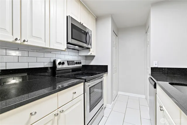a kitchen with stainless steel appliances granite countertop a sink and a stove