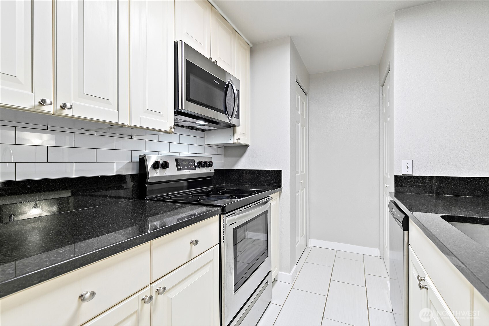 7453 Newcastle Golf Club Road, Unit M103 Newcastle, WA 98059 - Photo 5 of 18 a kitchen with stainless steel appliances granite countertop a sink and a stove