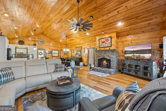 a dining room with wooden floor and chandelier