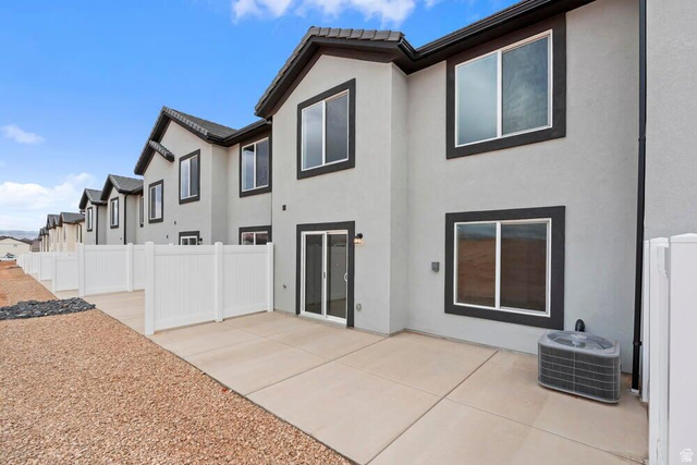 2123 Wolverine Way, Unit 2437 Washington, UT 84780 - Photo 2 of 40 Rear exterior featuring a concrete patio, vinyl fencing, and stucco siding