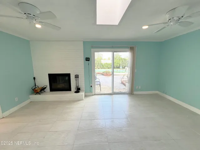 an empty room with windows and fireplace