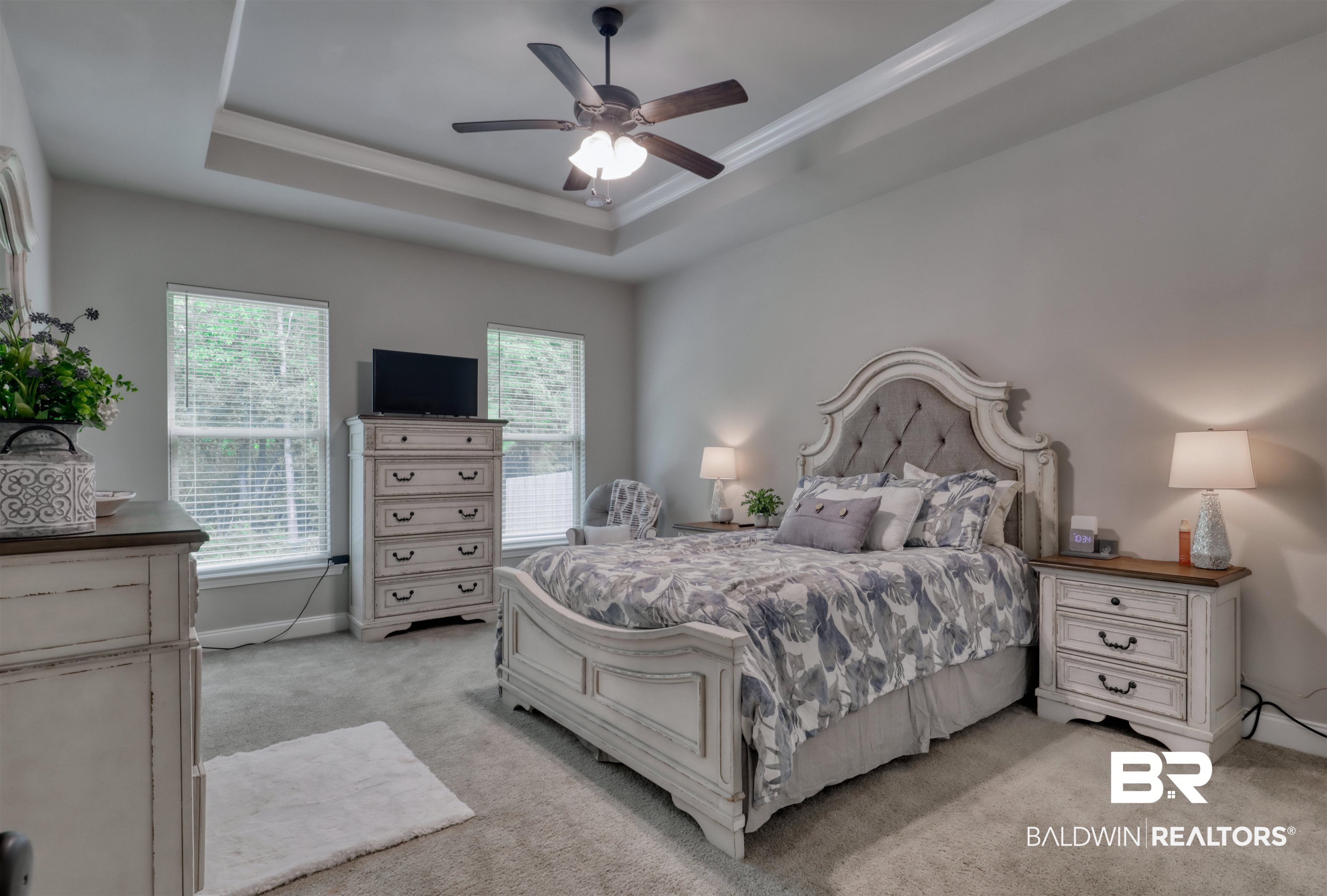 987 Gibson Court Foley, AL 36535 - Photo 15 of 34 Bedroom with ornamental molding, baseboards, light colored carpet, a tray ceiling, and a ceiling fan