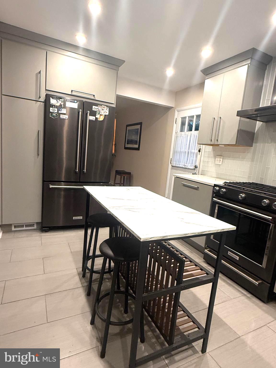 450 Foster Drive Springfield, PA 19064 - Photo 5 of 16 a kitchen with stainless steel appliances a dining table chairs and refrigerator