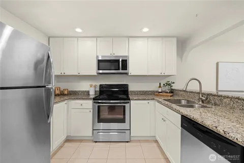 a kitchen with stainless steel appliances granite countertop a stove a refrigerator and a sink