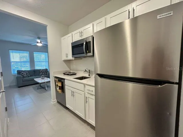 a kitchen with stainless steel appliances a refrigerator sink and microwave