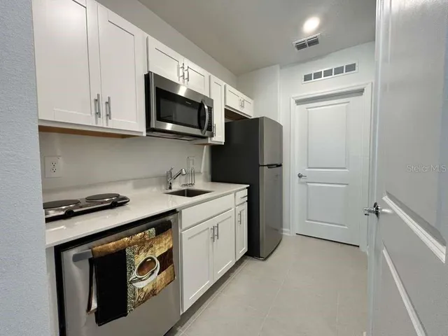 a kitchen with stainless steel appliances white cabinets and a stove top oven