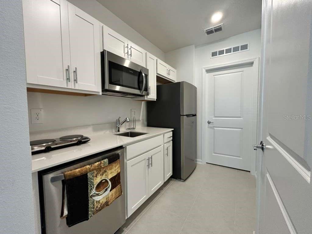 3258 Armstrong Avenue Clermont, FL 34714 - Photo 9 of 18 a kitchen with stainless steel appliances white cabinets and a stove top oven