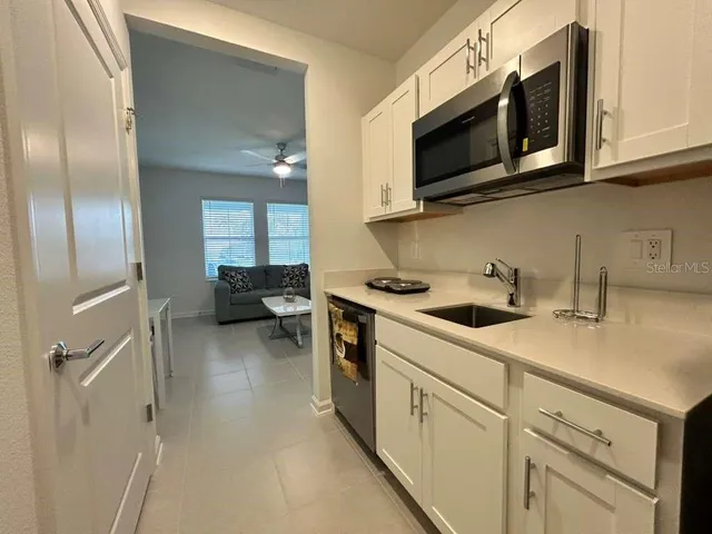 a kitchen with stainless steel appliances granite countertop a sink and a microwave
