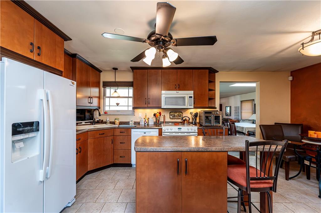 2037 Ridge Road Jeannette, PA 15644 - Photo 7 of 24 a kitchen with stainless steel appliances granite countertop a dining table chairs stove and refrigerator