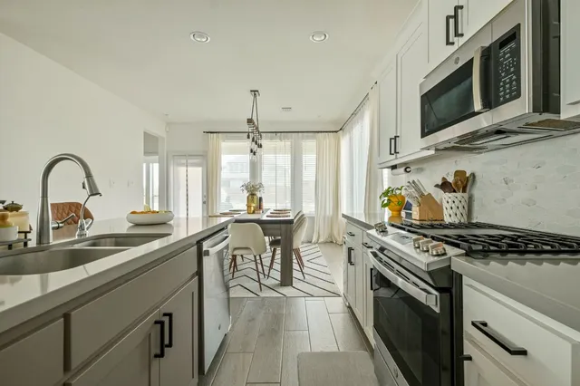 a kitchen with stainless steel appliances a sink a stove and cabinets