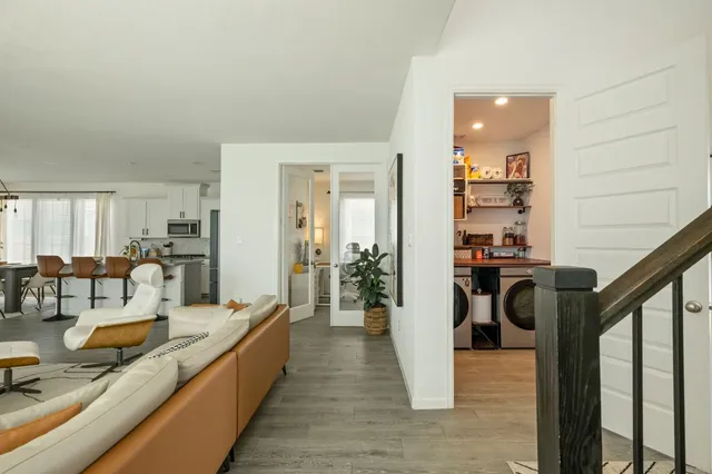 a view of a living room and kitchen with furniture wooden floor and windows