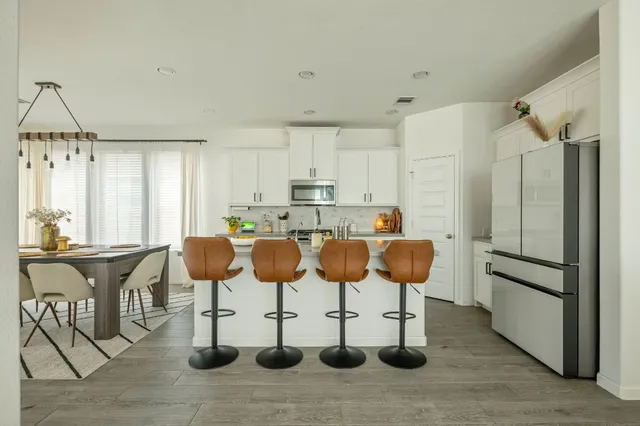 a kitchen with a refrigerator and chairs