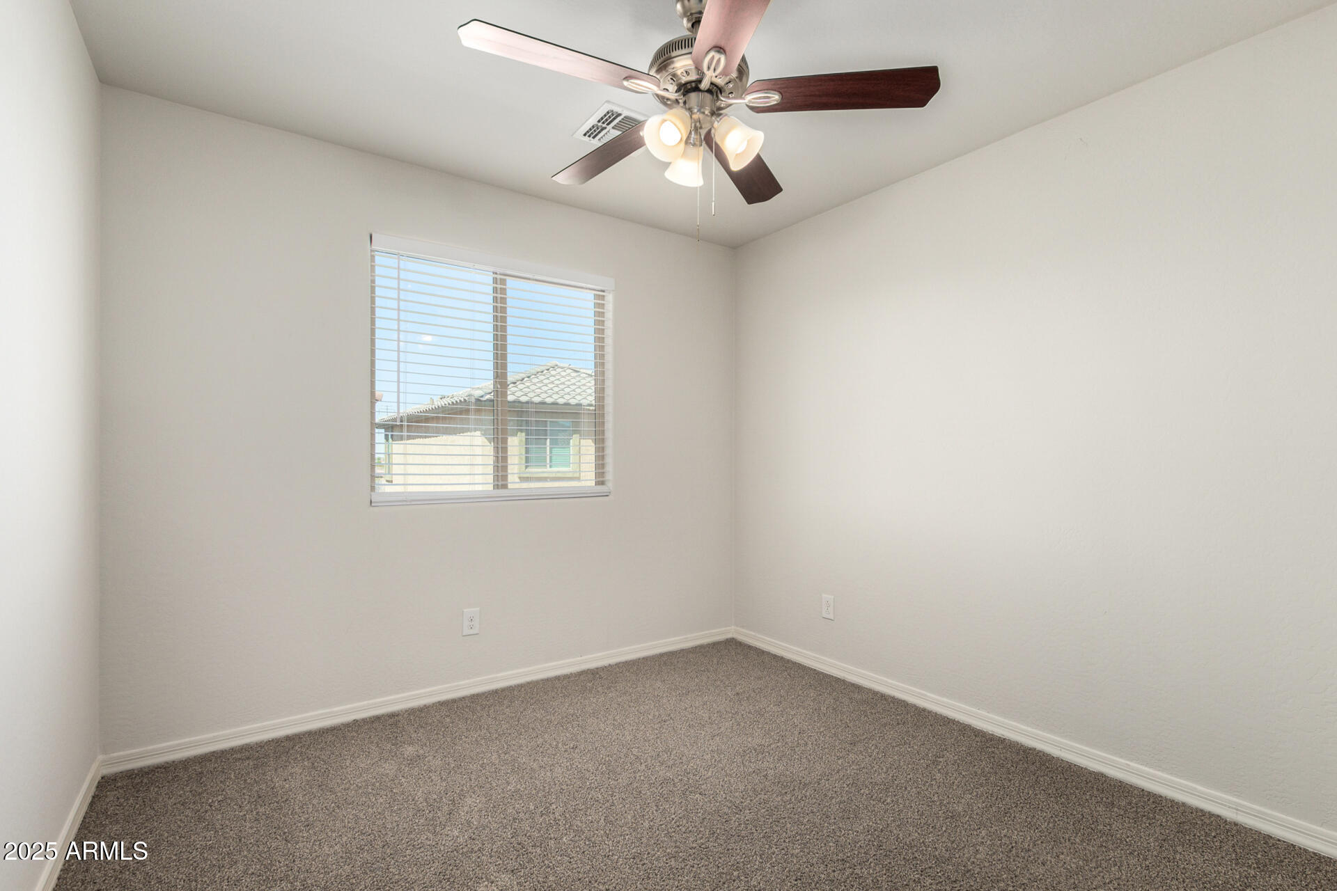 5470 Fulton Street Phoenix, AZ 85043 - Photo 25 of 33 an empty room with a window and a fan