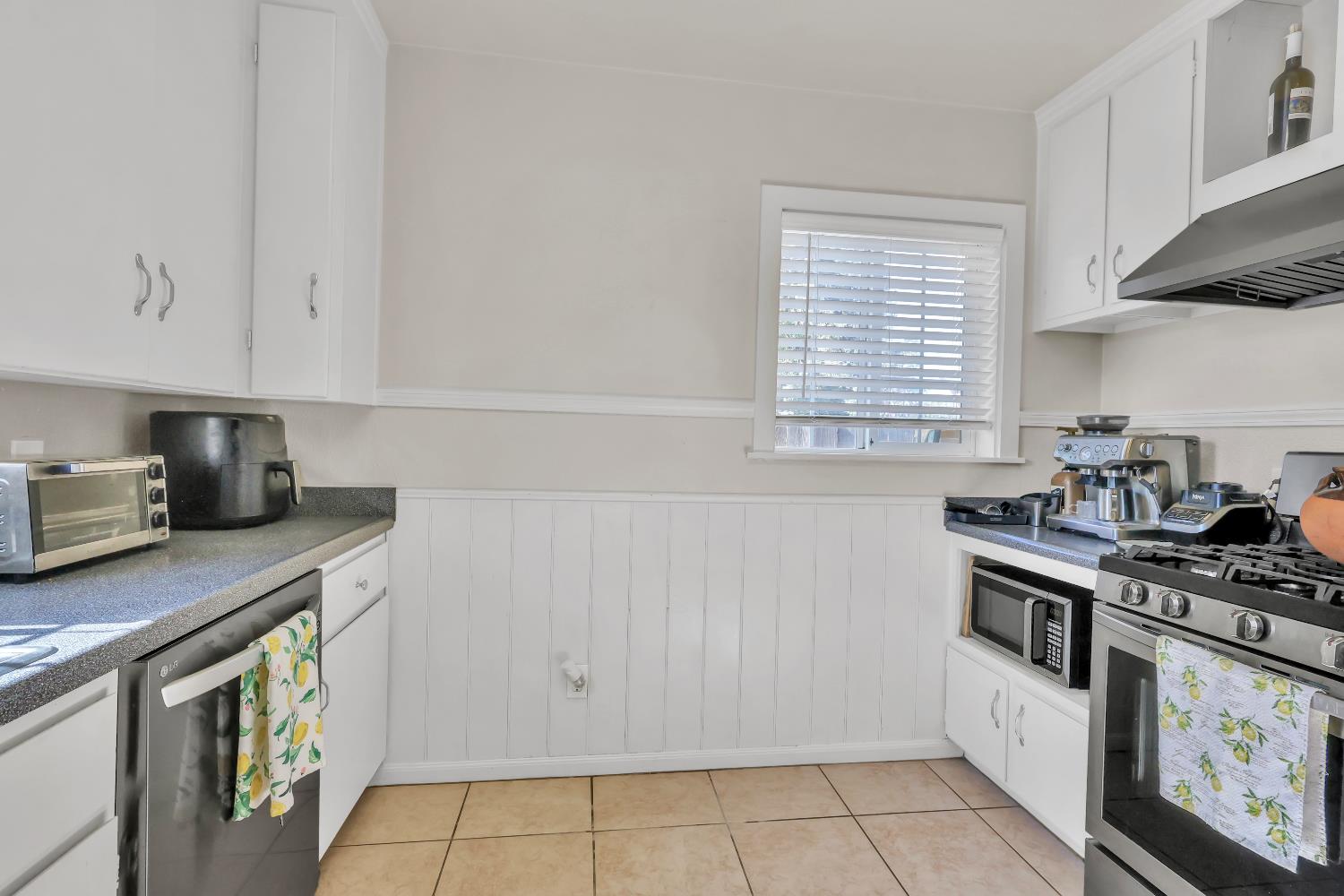 606 West Turner Road Lodi, CA 95240 - Photo 17 of 41 a kitchen with stainless steel appliances a stove a sink and white cabinets