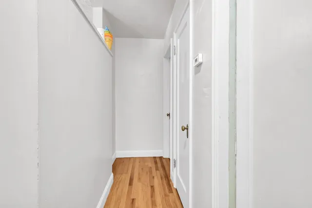 a view of a livingroom with wooden floor and a large window