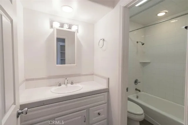 a bathroom with a granite countertop sink a toilet and shower